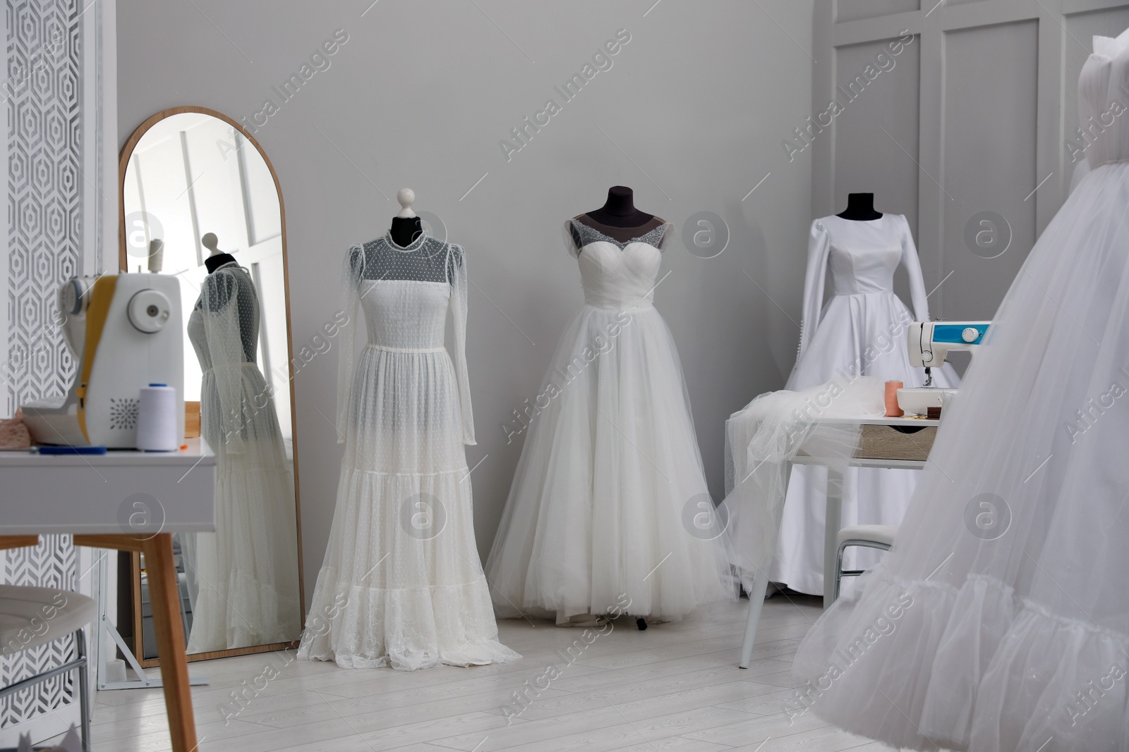 Photo of Dressmaking workshop interior with wedding dresses and equipment