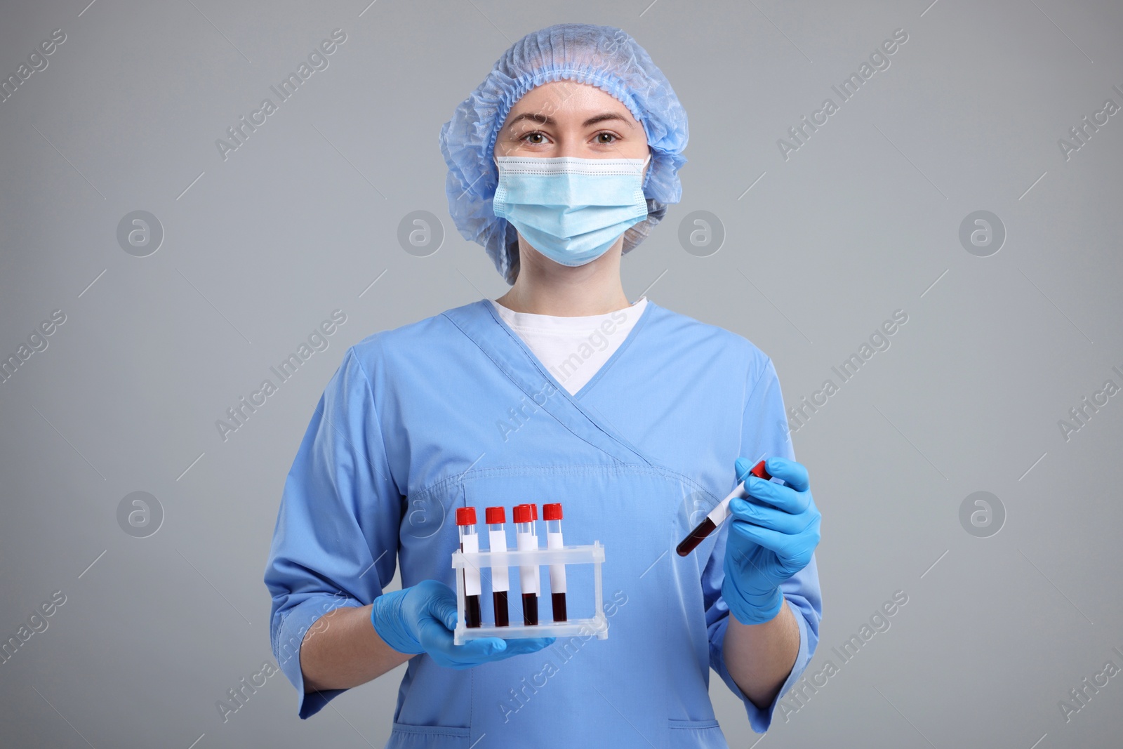 Photo of Laboratory testing. Doctor with blood samples in tubes on light grey background