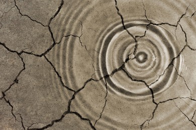Save environment. Rippled water on dry cracked land, top view