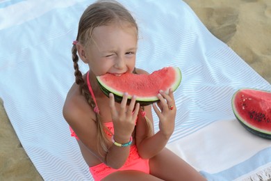Photo of Cute little girl eating juicy watermelon on beach