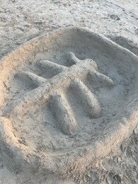 Palm tree made of sand on beach