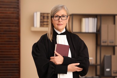 Photo of Portrait of judge in court dress with book indoors