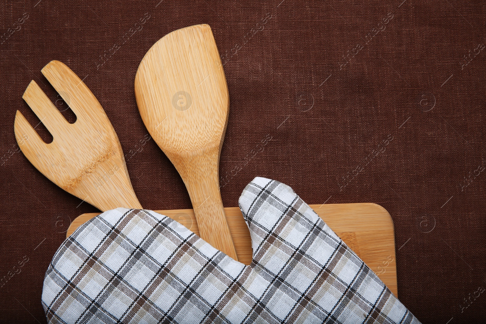 Photo of Flat lay composition with oven glove and kitchenware on fabric