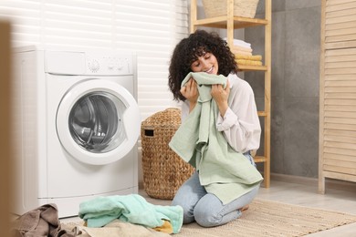Woman with laundry near washing machine indoors