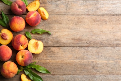 Fresh sweet peaches on wooden table, flat lay. Space for text