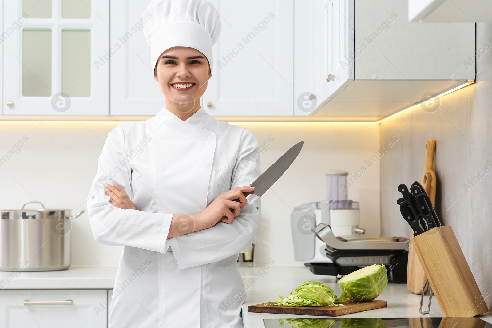 Photo of Portrait of professional chef holding knife in kitchen