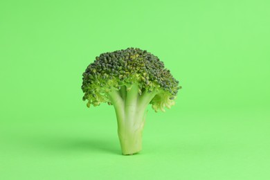 Fresh raw broccoli on light green background