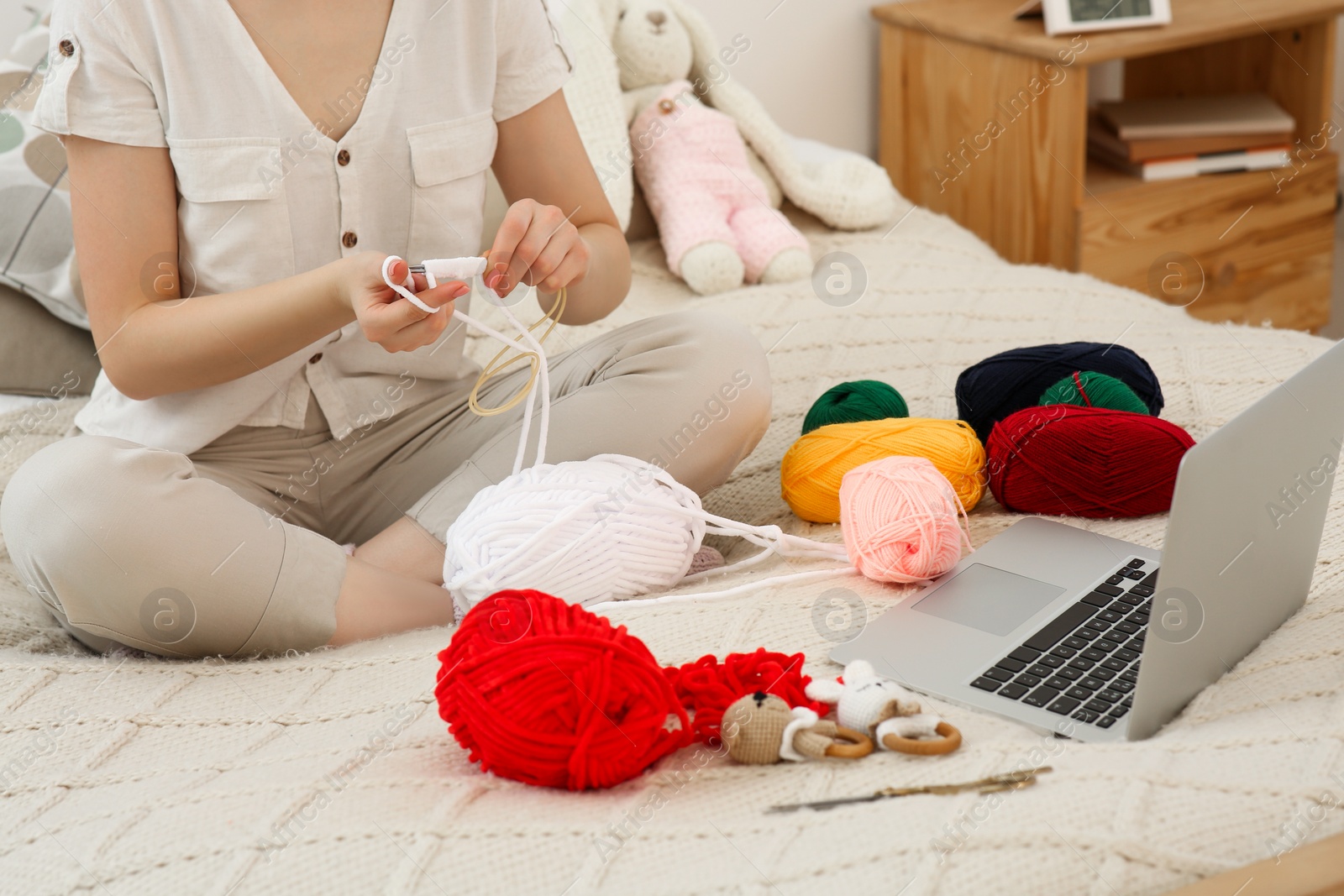 Photo of Woman learning to knit with online course at home, closeup. Handicraft hobby