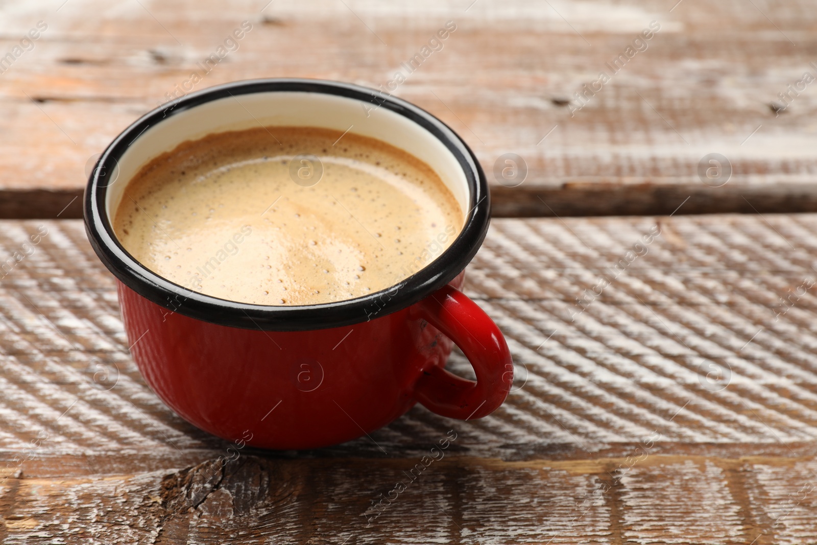 Photo of Cup of aromatic coffee on wooden table, closeup. Space for text