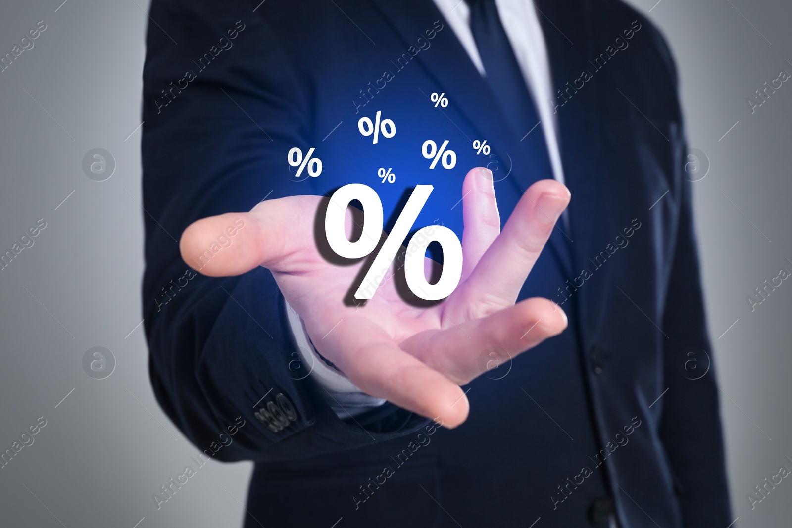 Image of Man showing virtual percent sign on light grey background, closeup. Discount concept