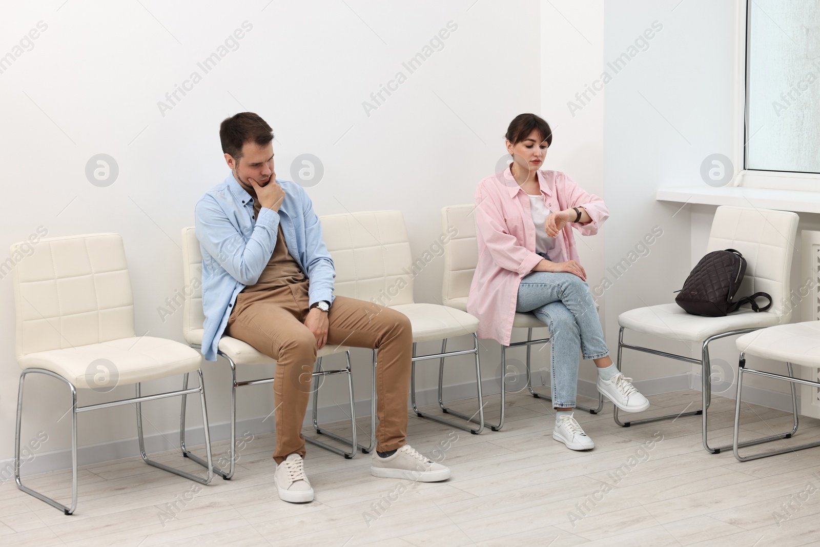 Photo of Man and woman waiting for job interview indoors