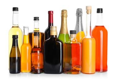 Photo of Bottles of different alcoholic drinks isolated on white