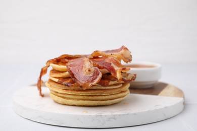 Delicious pancakes with bacon and honey on white table, closeup