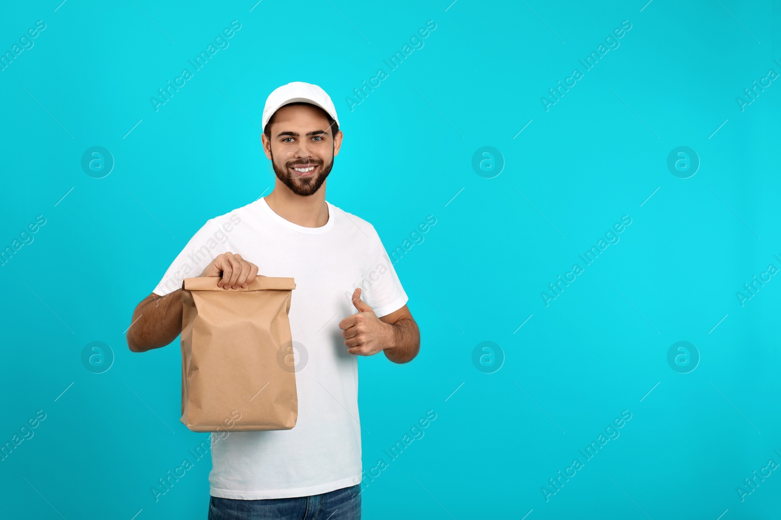 Photo of Young courier with paper bag on color background, space for text. Food delivery service
