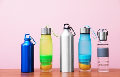 Photo of Different water bottles for sports on color background