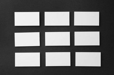 Photo of Blank business cards on black background, flat lay. Mockup for design