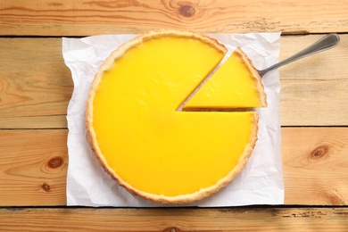 Photo of Delicious homemade lemon pie on wooden table, top view