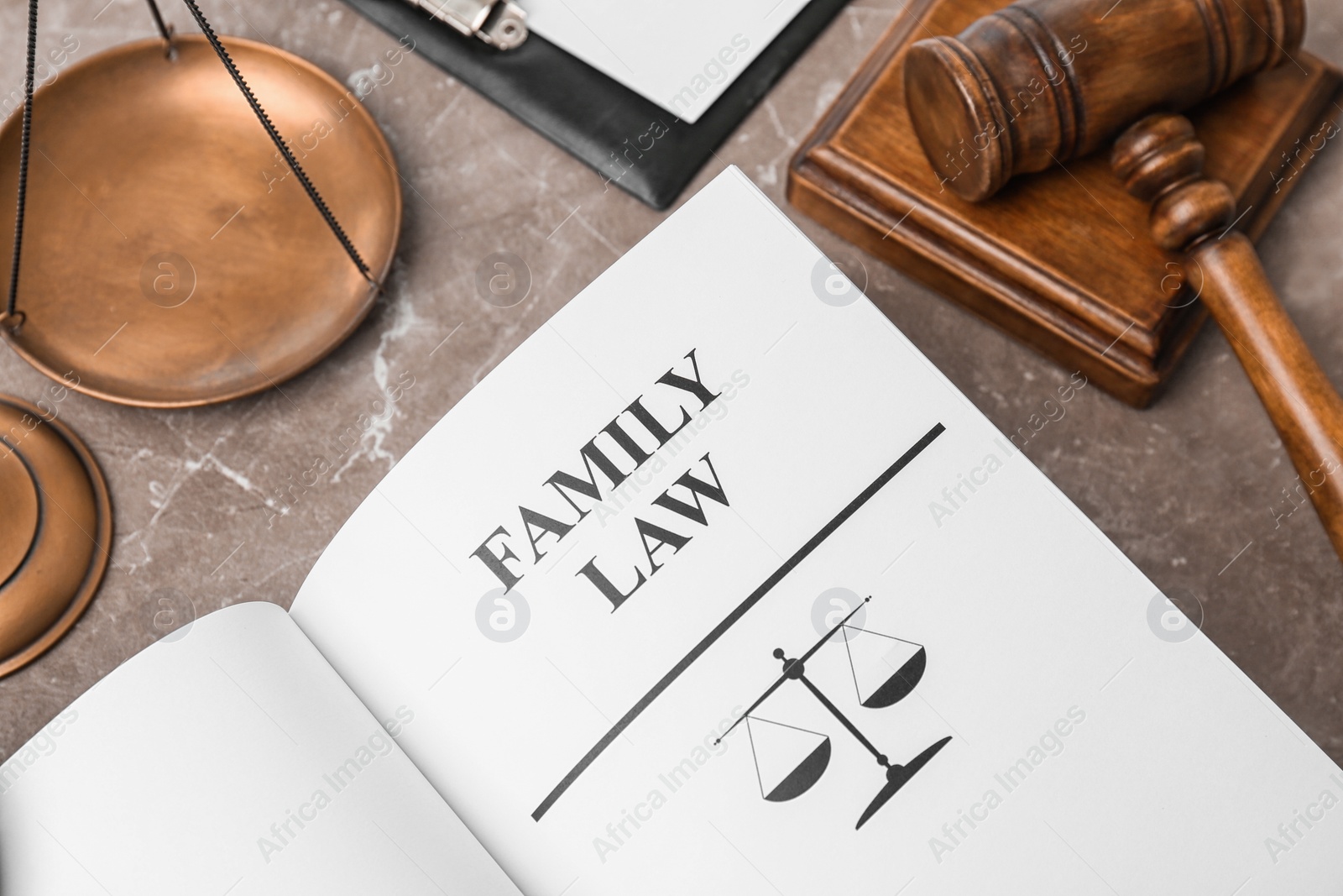 Photo of Open book with words FAMILY LAW, scales of justice and gavel on table, closeup
