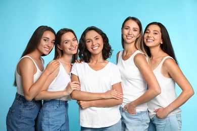 Photo of Happy women on light blue background. Girl power concept