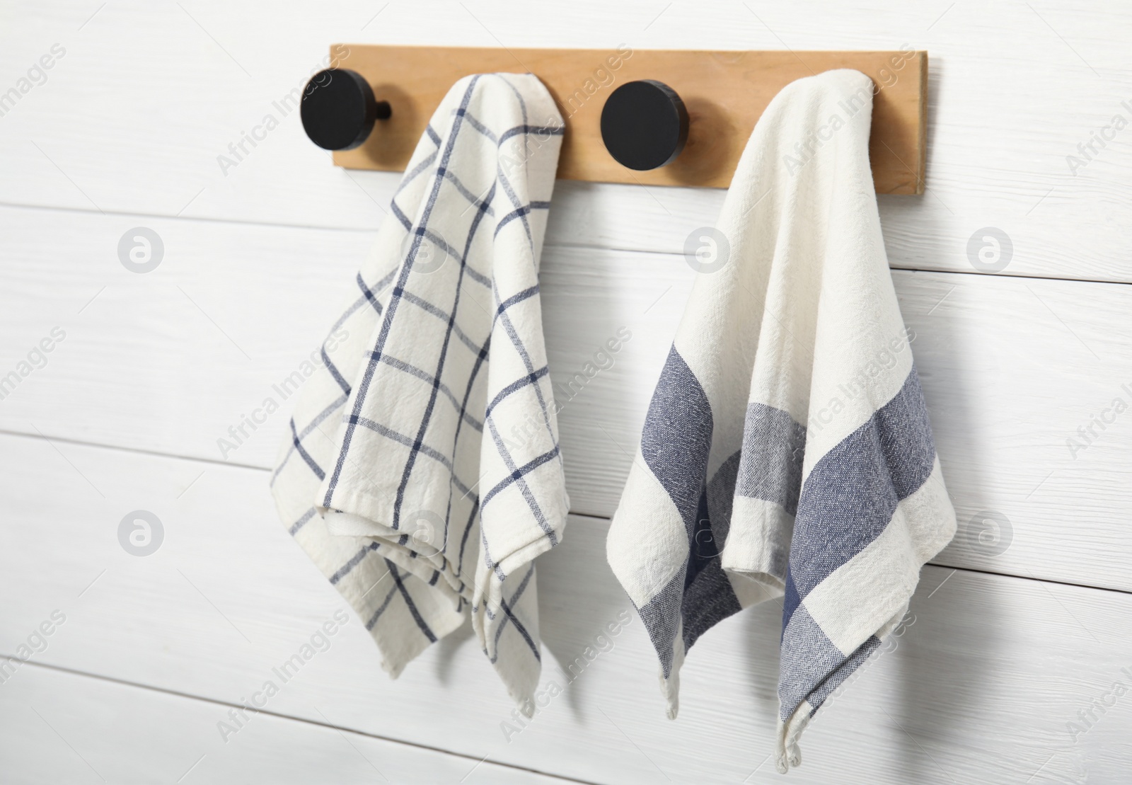 Photo of Different clean kitchen towels hanging on rack