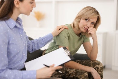 Photo of Psychotherapist working with military woman in office