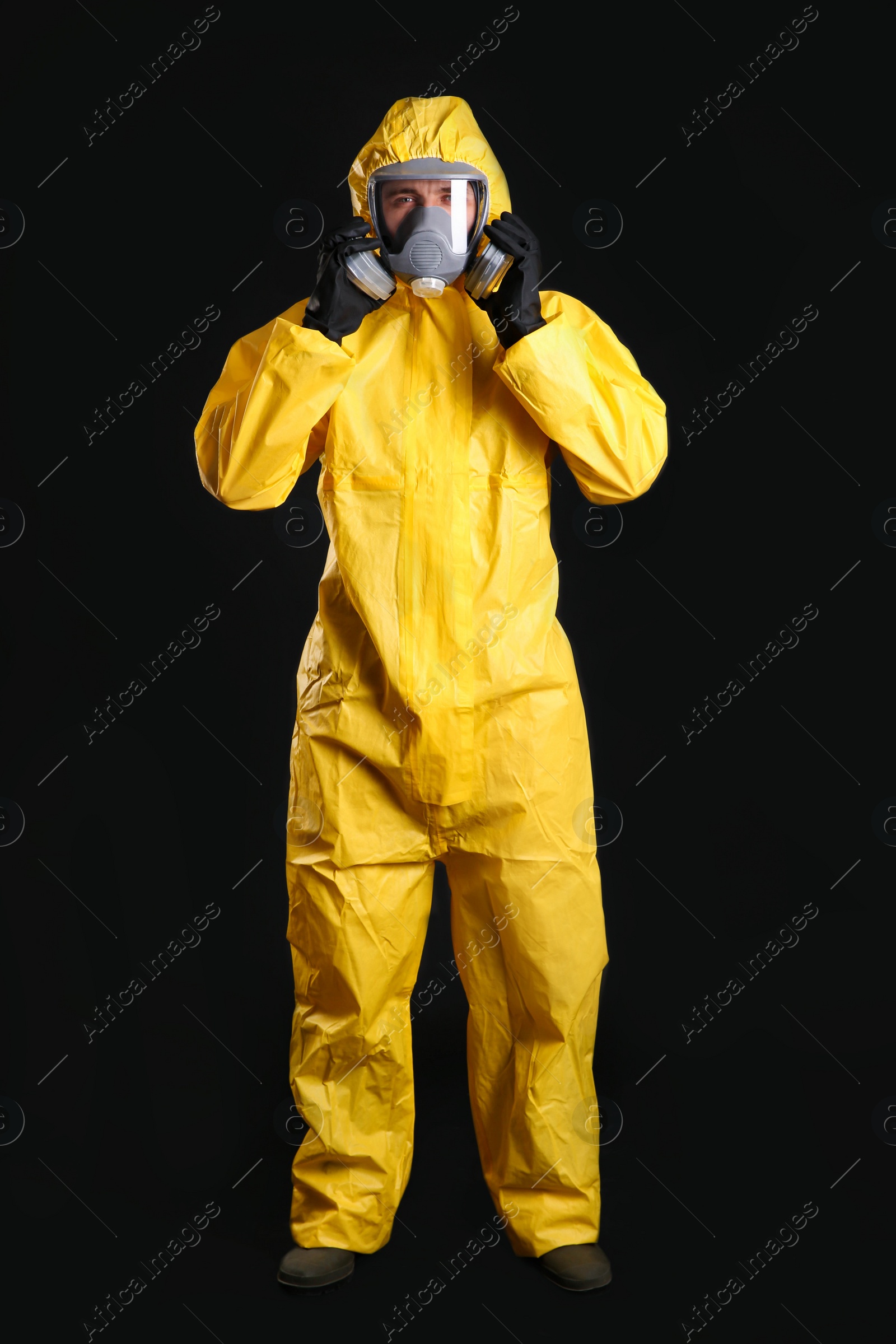 Photo of Man wearing chemical protective suit on black background. Virus research