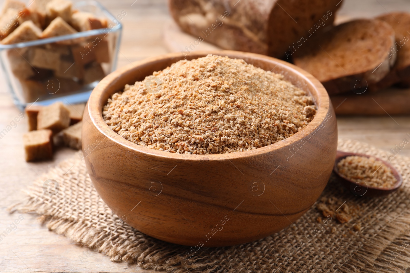 Photo of Fresh breadcrumbs in bowl on wooden table