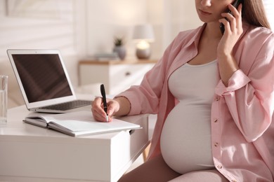 Photo of Pregnant woman working at home, closeup. Maternity leave