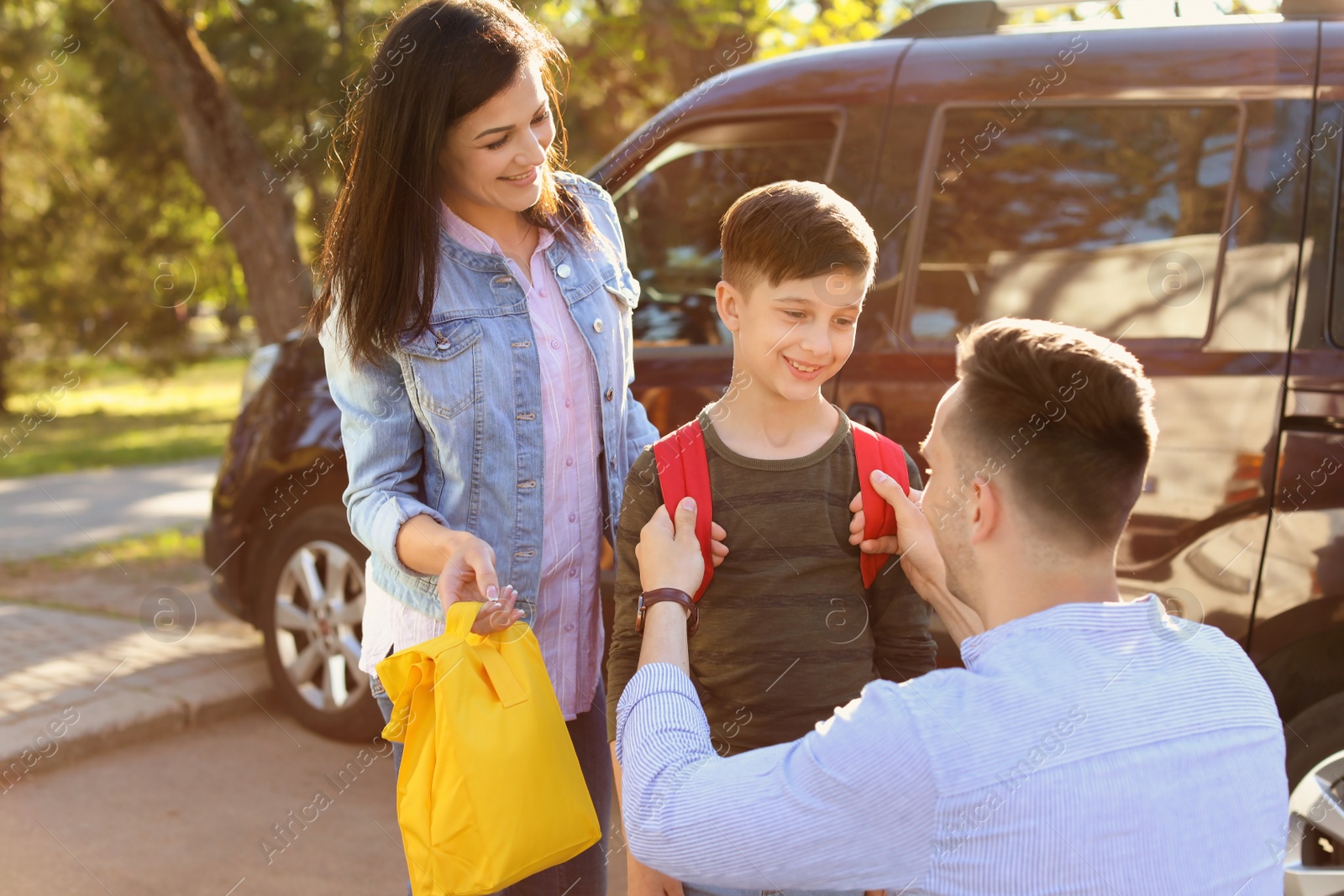 Photo of Young parents saying goodbye to their little child near school