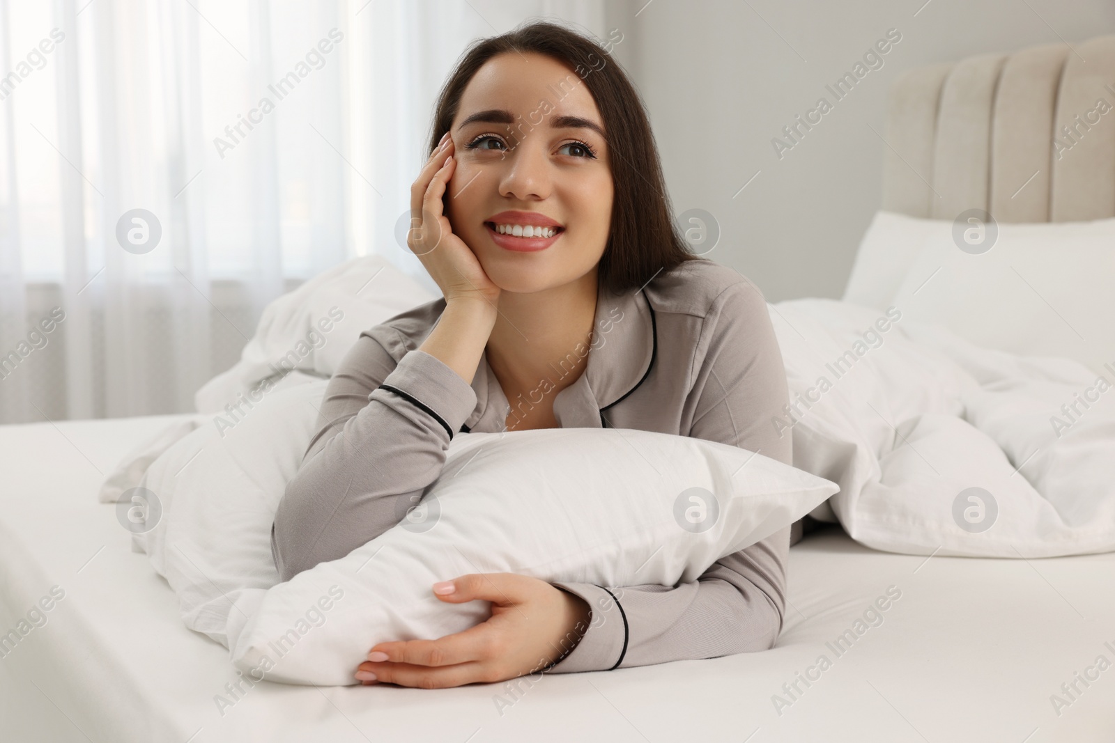 Photo of Beautiful young woman lying on bed at home
