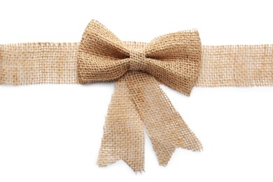 Photo of Burlap ribbon with pretty bow on white background, top view