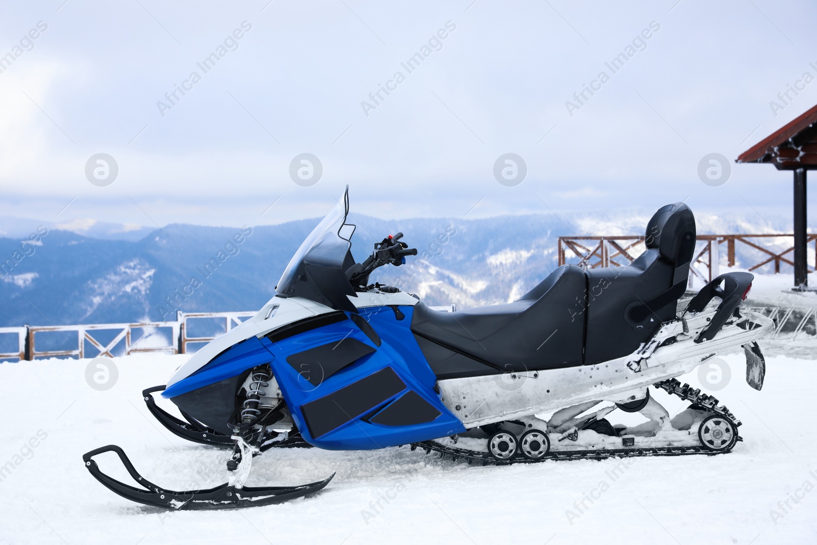 Photo of Modern snowmobile on hill at mountain ski resort