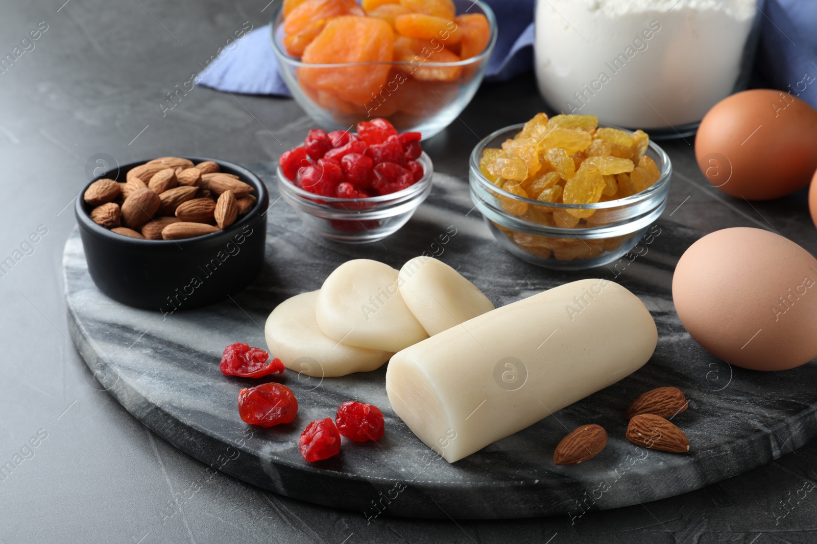 Photo of Marzipan and other ingredients for homemade Stollen on grey table. Baking traditional German Christmas bread