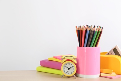 Photo of Different school stationery and alarm clock on table against white background, space for text. Back to school