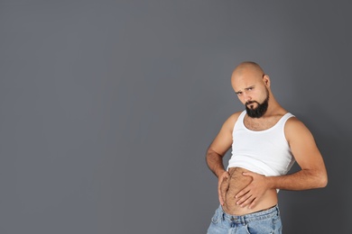 Portrait of overweight man and space for text on gray background