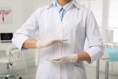 Young gynecologist holding something in modern clinic, closeup
