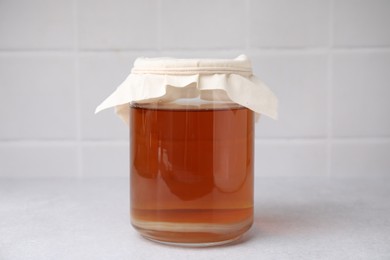 Photo of Tasty kombucha in glass jar on white table