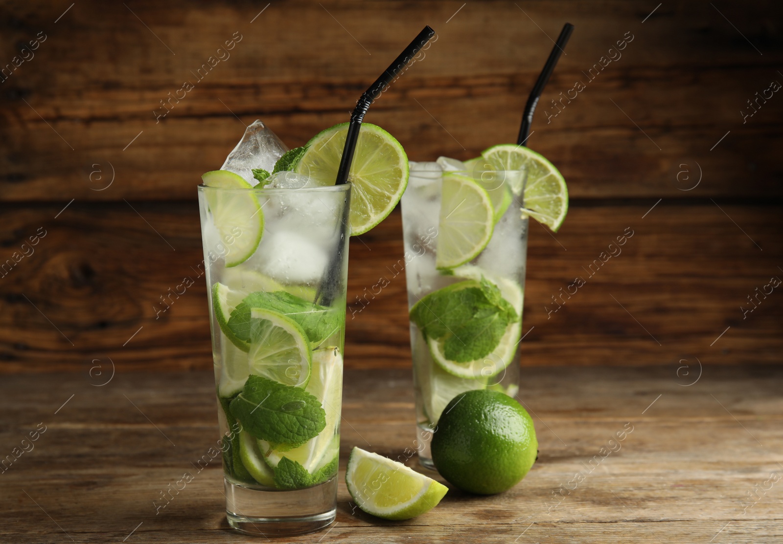 Photo of Delicious mojito and ingredients on wooden table