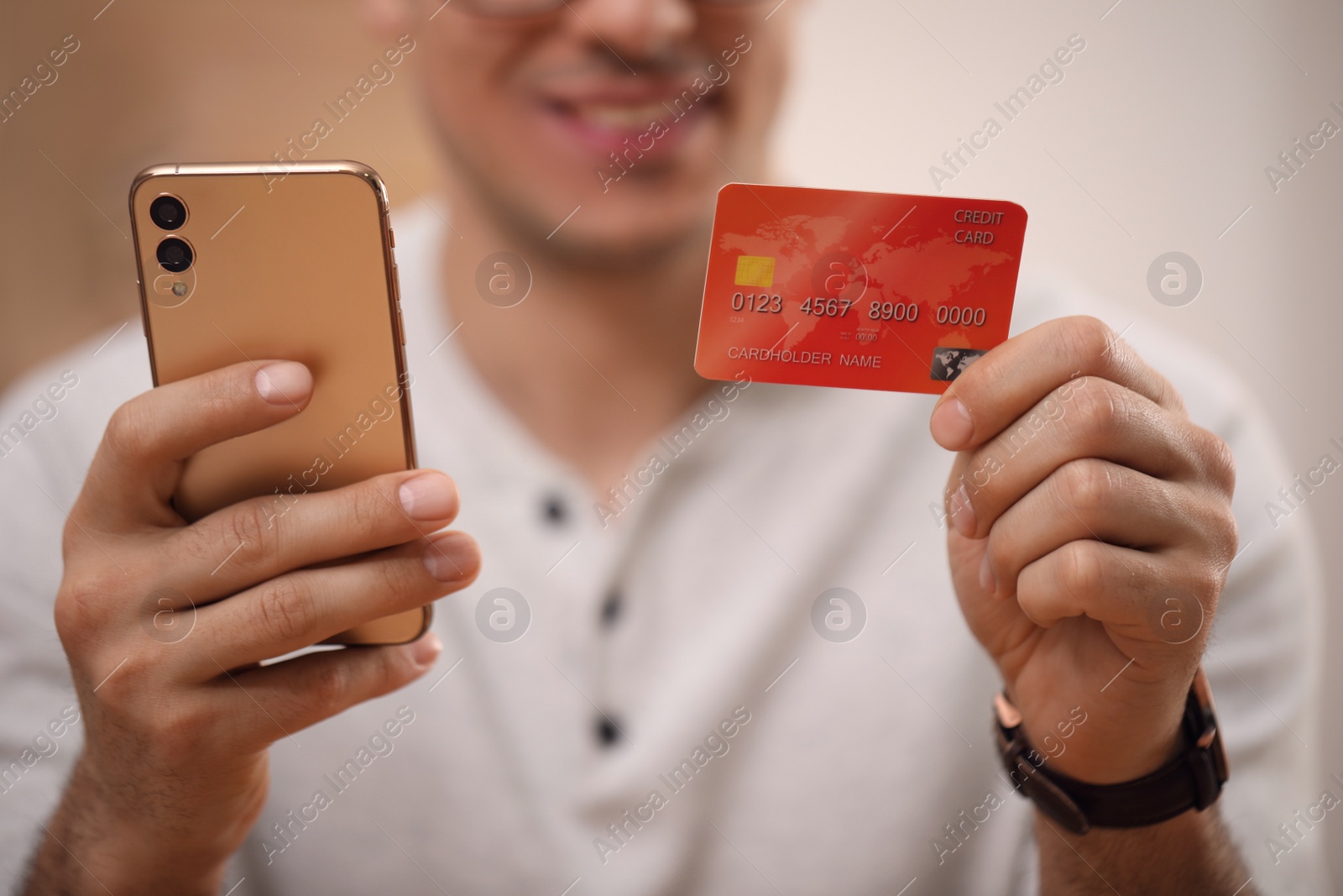 Photo of Man using smartphone and credit card for online payment, closeup