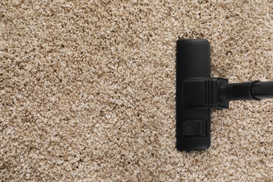 Photo of Hoovering carpet with modern vacuum cleaner indoors, top view. Space for text