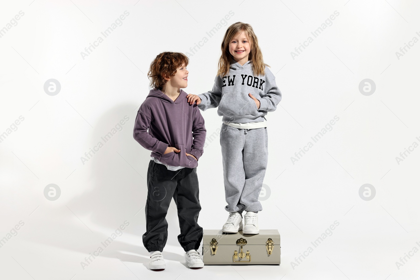 Photo of Fashion concept. Stylish children with vintage suitcase on white background