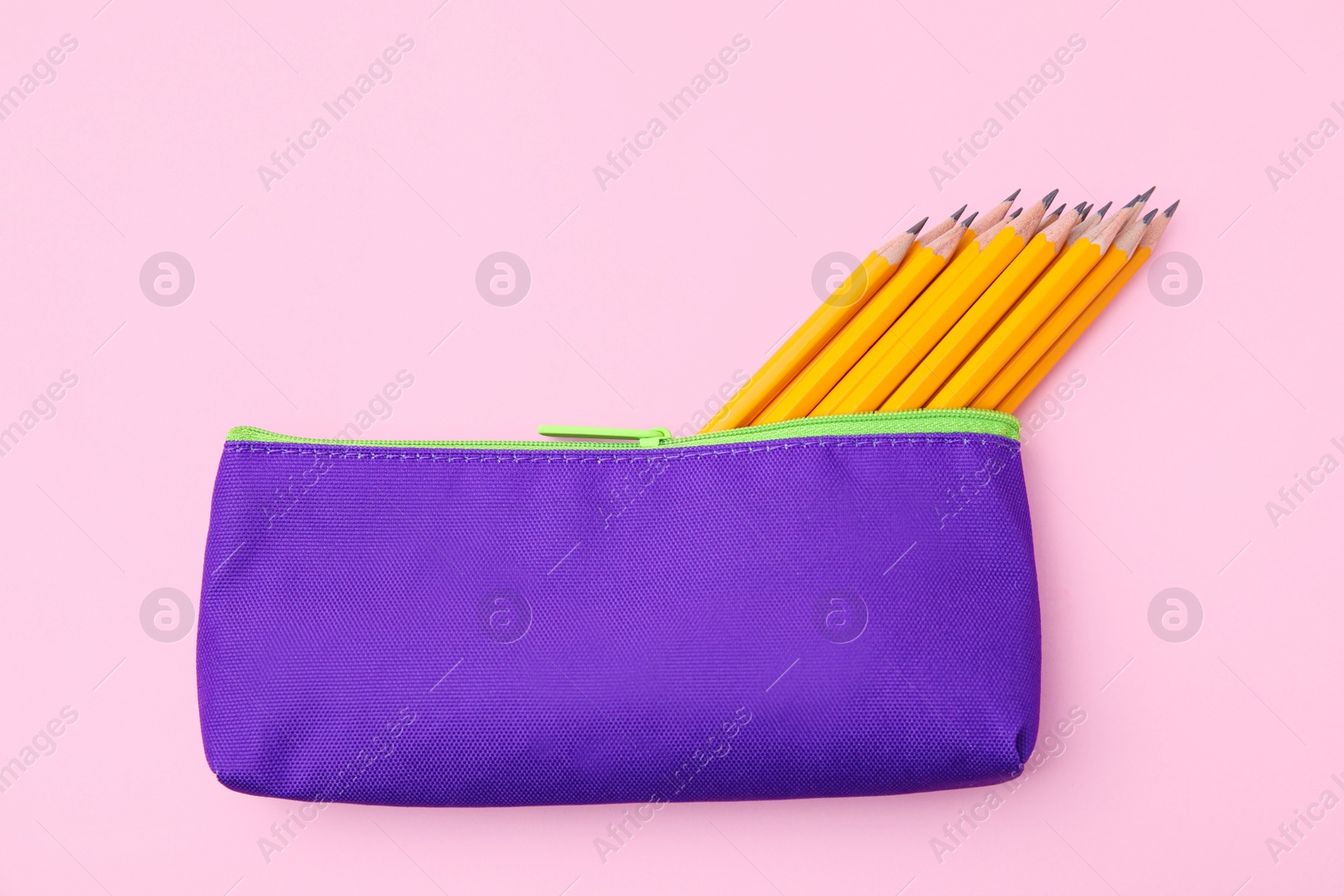 Photo of Many sharp pencils in pencil case on pink background, top view