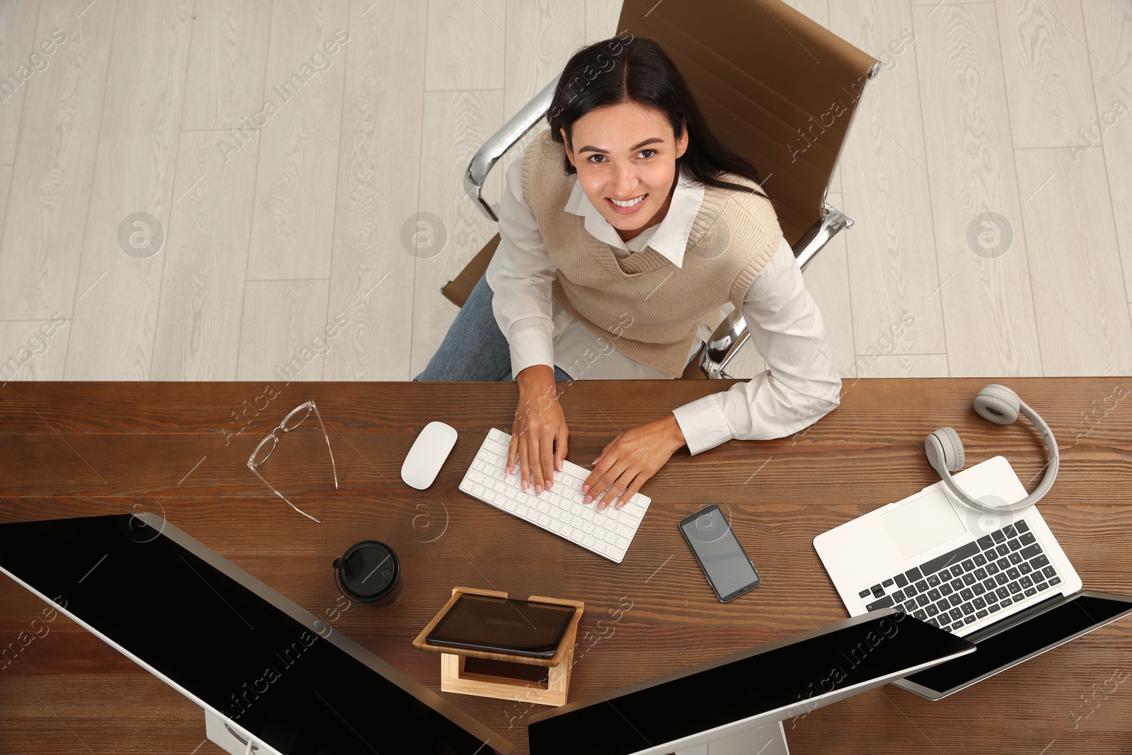 Photo of Happy programmer working at desk in office, top view