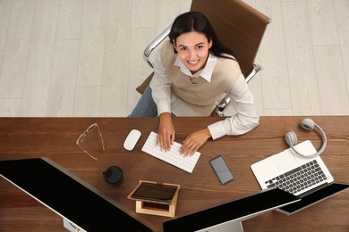 Photo of Happy programmer working at desk in office, top view