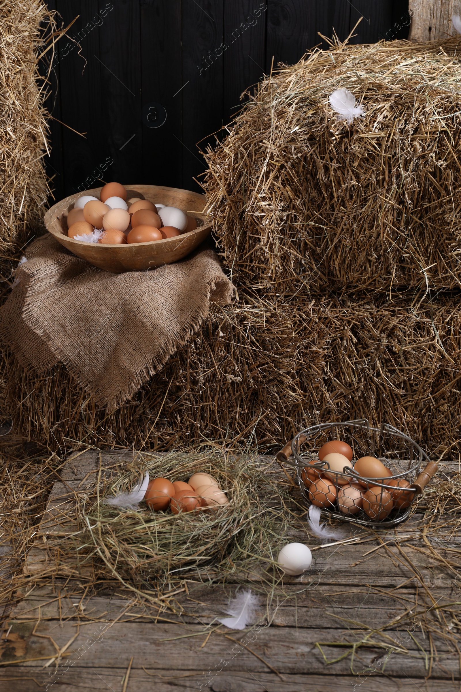 Photo of Fresh chicken eggs and dried straw bales in henhouse