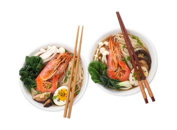 Delicious ramen with shrimps, eggs and chopsticks isolated on white, top view. Noodle soup