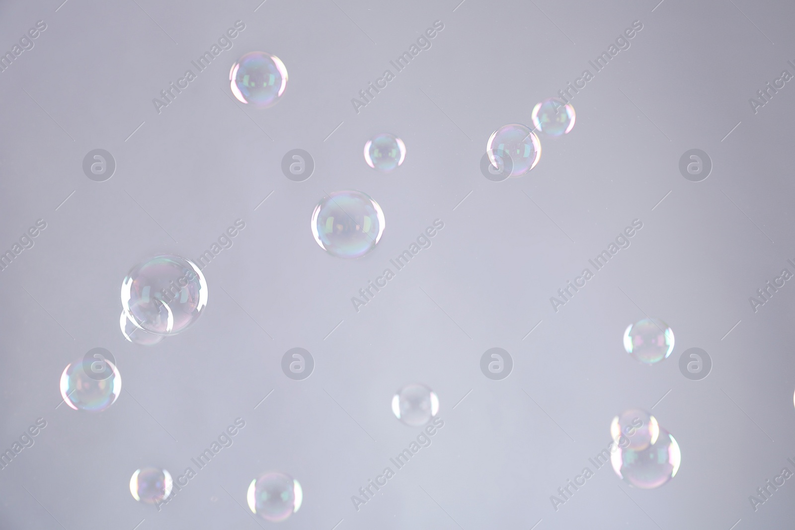 Photo of Beautiful translucent soap bubbles on grey background