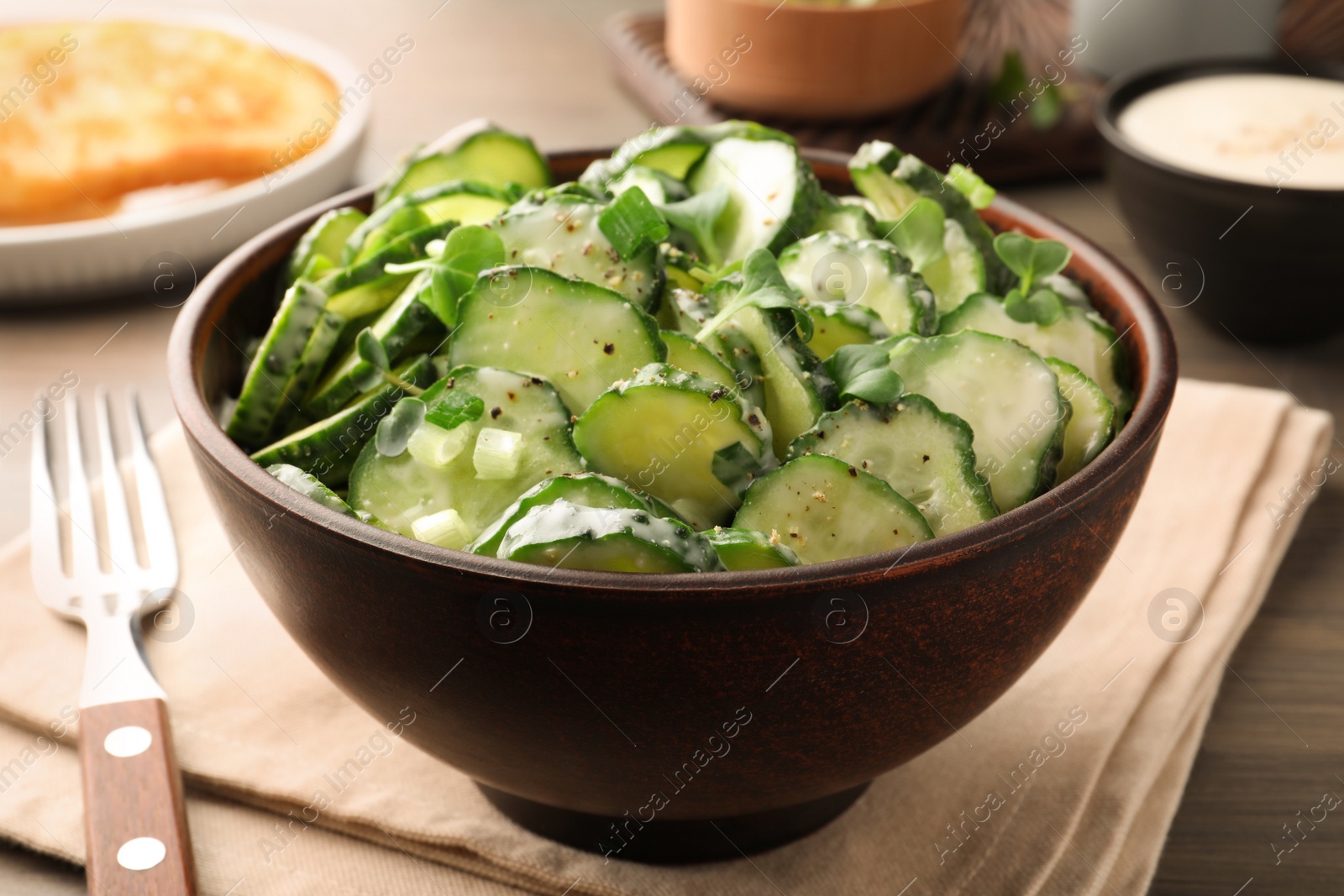 Photo of Delicious cucumber salad on wooden table, closeup