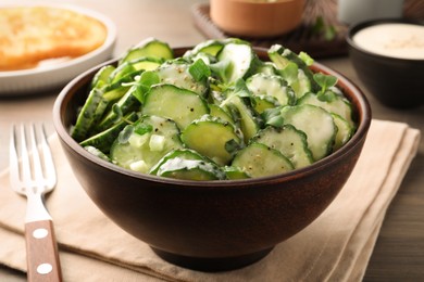 Delicious cucumber salad on wooden table, closeup