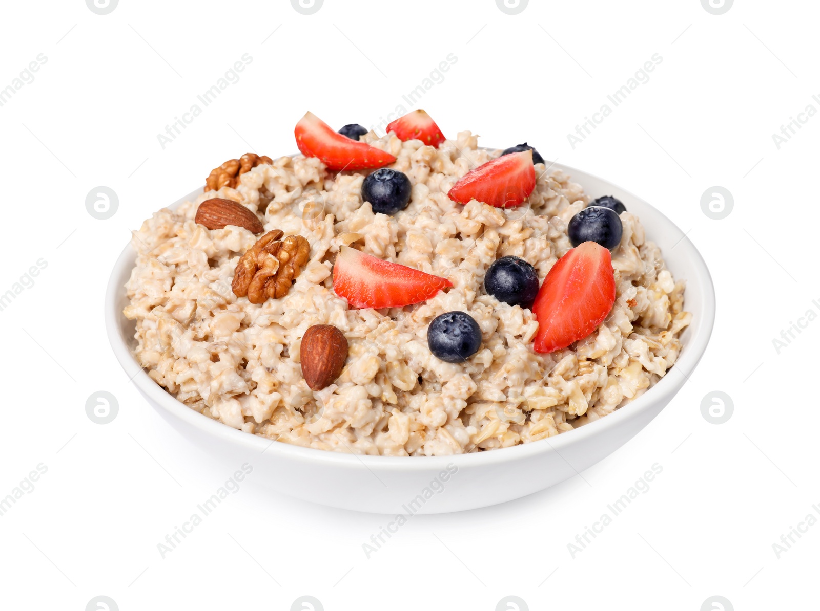 Photo of Tasty boiled oatmeal with berries and nuts in bowl isolated on white